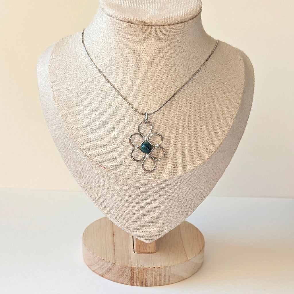 Necklace with a pendant on a mannequin bust against a plain background