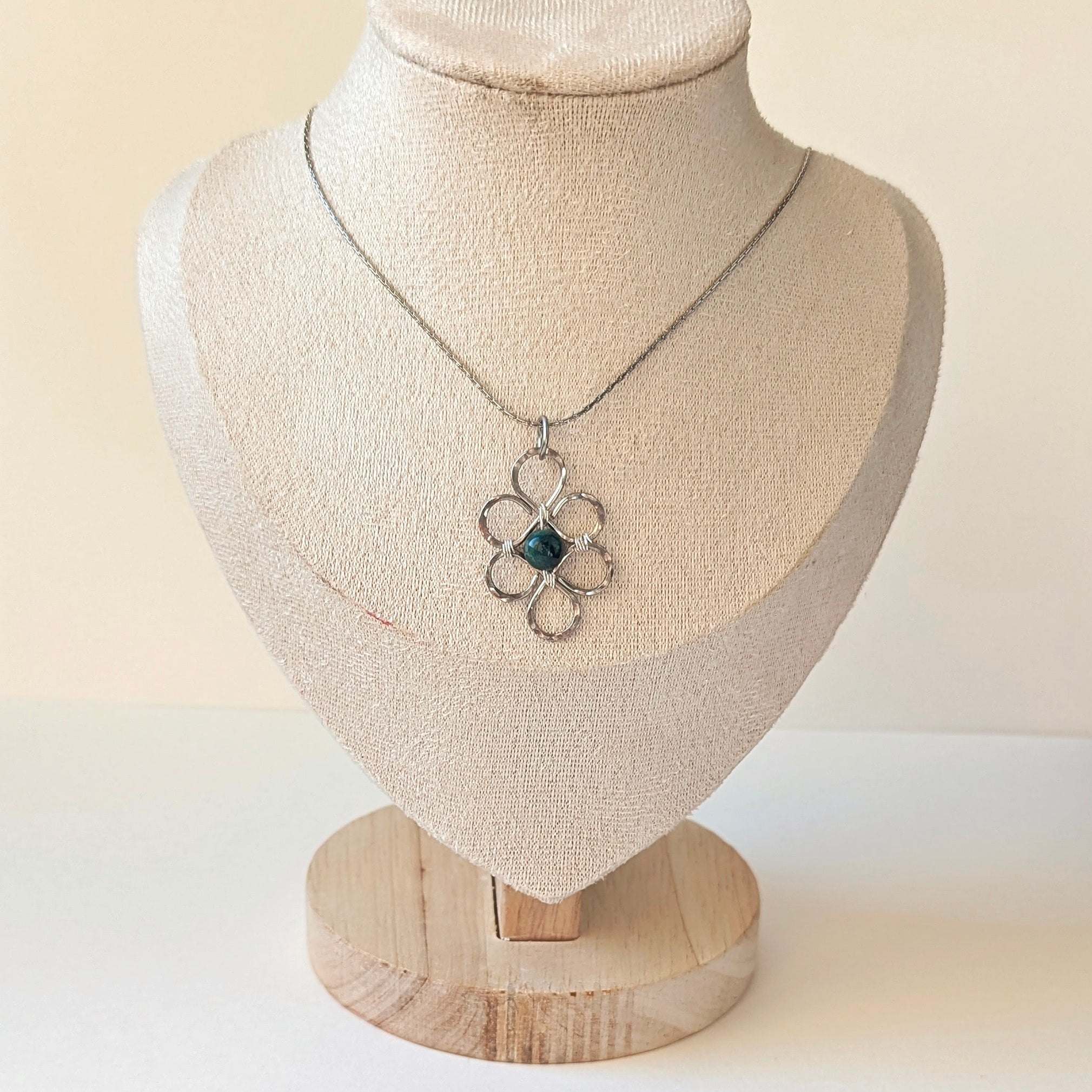 Necklace with a pendant on a mannequin bust against a plain background